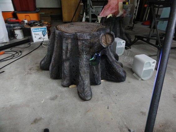 Finished weather resistant tree stump prop housing a projector